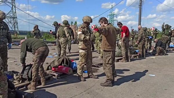 Российские военнослужащие досматривают сдавшихся в плен украинских военнослужащих и боевиков националистического батальона Азов на территории комбината Азовсталь в Мариуполе. Стоп-кадр видео