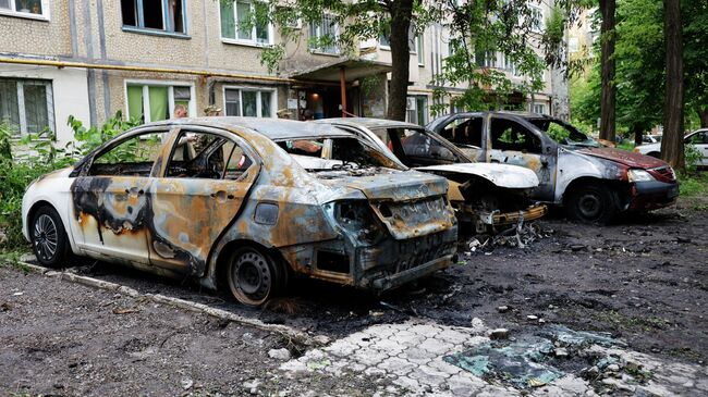 Уничтоженные в результате обстрелов ВСУ легковые автомобили в Куйбышевском районе Донецка