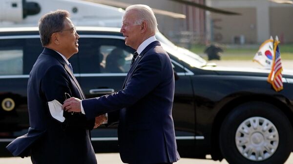 Министр иностранных дел Южной Кореи Пак Джин приветствует президента США Джо Байдена на авиабазе Осан