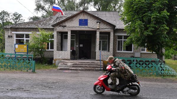 A patrol of LPR people's militia passes by the former Executive Committee of the Port city council in the liberated village of Yatskovka
