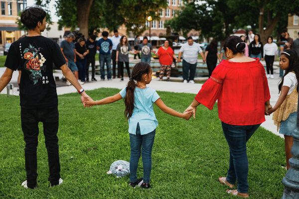 Люди собираются на главной площади города Ювальде для молитвы после массовой стрельбы в начальной школе в Ювалде, штат Техас