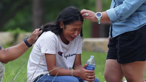 Девочка плачет после стрельбы в начальной школе в Ювалде, штате Техас