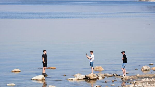 Люди фотографируются на берегу озера Байкал в республике Бурятия