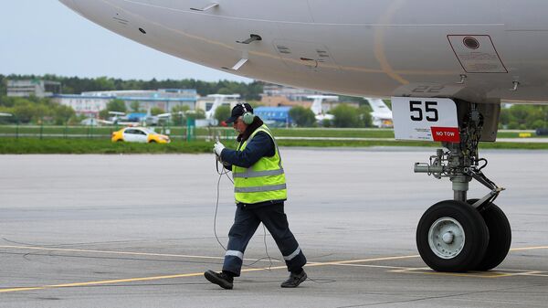 Техник возле авиалайнера МС-21-310 с двигателем ПД-14 на взлетно-посадочной полосе перед началом испытаний самолета в Жуковском