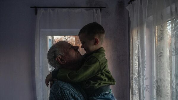 Виктор Александрович с внуком Самсоном в комнате своего дома в станице Луганская Луганской народной республики.