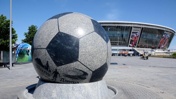 Мраморный футбольный мяч перед стадионом Донбасс-Арена в Донецке.
