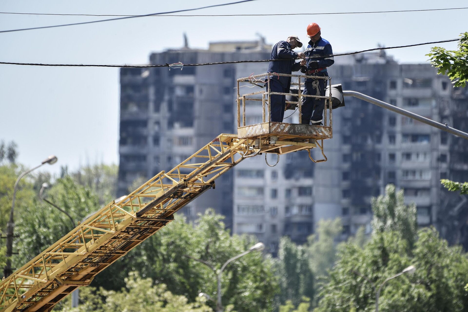 Электромонтеры восстанавливают электроснабжение на одной из улиц в Мариуполе - РИА Новости, 1920, 29.07.2022