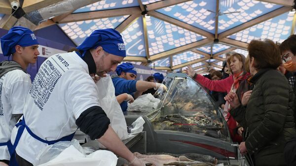 Посетители фестиваля Рыбная неделя на открывшемся рыбном рынке между Манежной площадью и площадью Революции в Москве