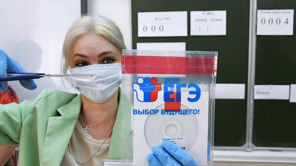Учительница вскрывает конверт с диском, в котором содержатся задания для единого государственного экзамена по русскому языку. Архивное фото