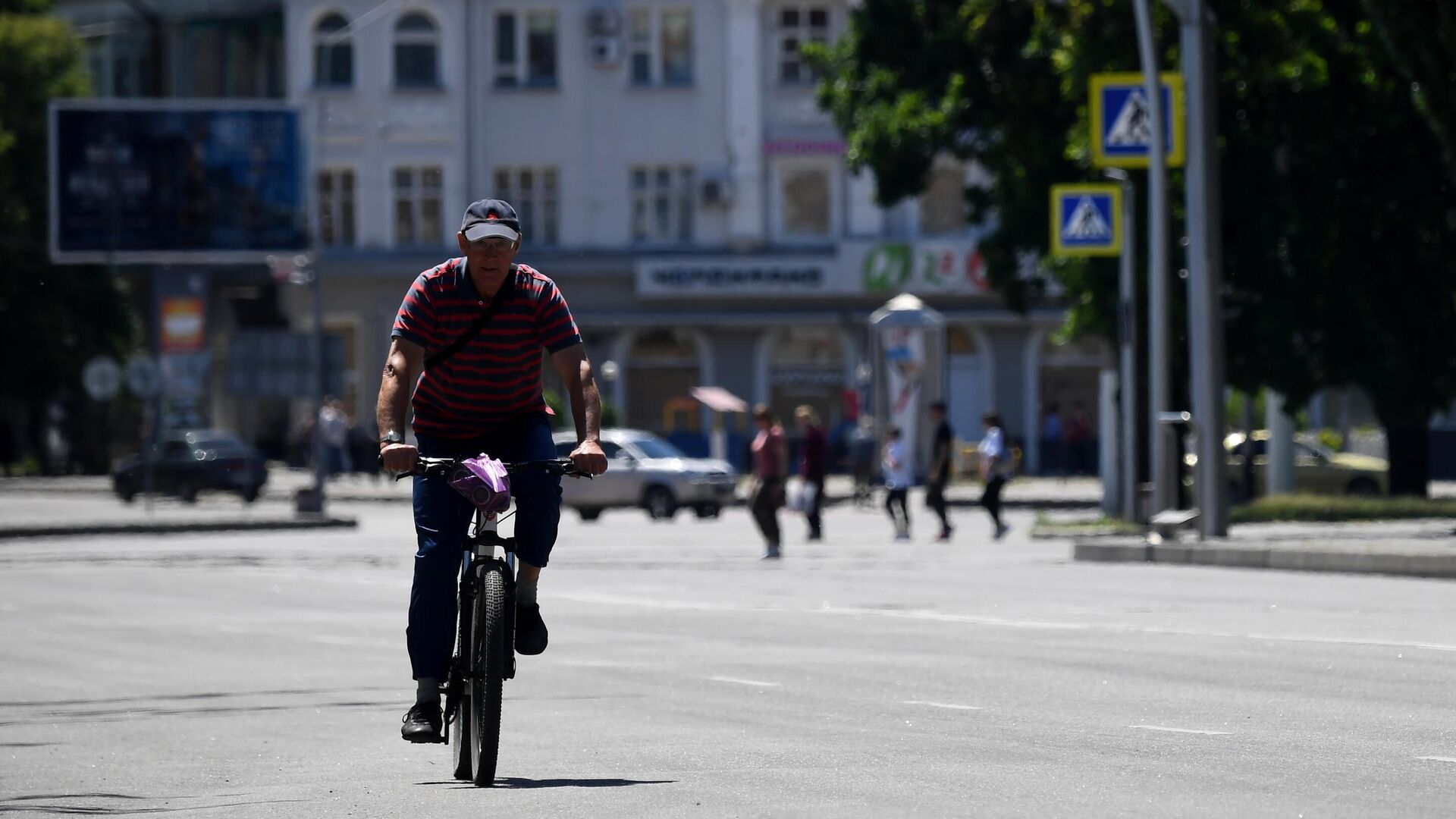 Мужчина едет на велосипеде по одной из улиц в Мелитополе - РИА Новости, 1920, 30.05.2022