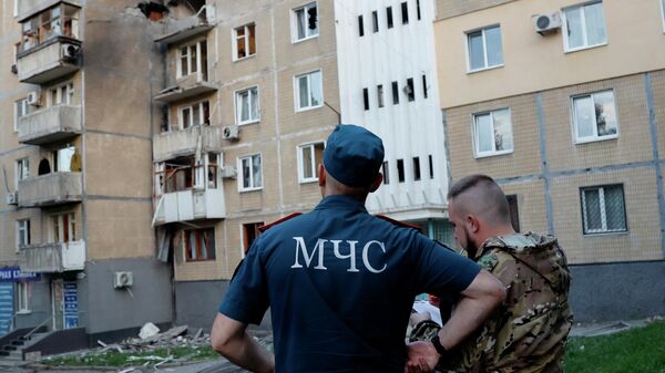 Сотрудники МЧС ДНР работают на месте обстрела ВСУ в Донецке