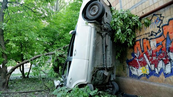 Поврежденный в результате обстрела ВСУ жилого сектора автомобиль в Калининском районе Донецка