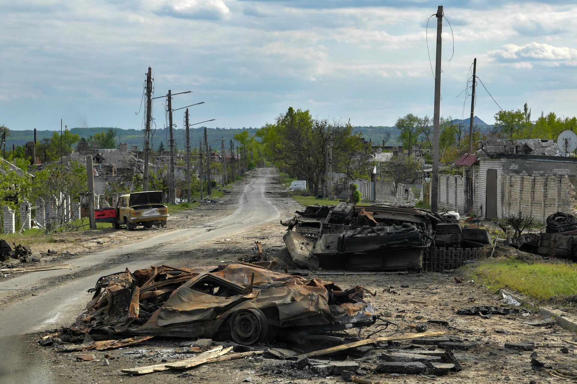 Сгоревшая военная техника и автомобили на одной из улиц в городе Рубежное - РИА Новости, 1920, 30.05.2022