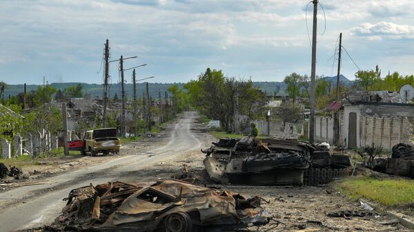 Сгоревшая военная техника и автомобили на одной из улиц в городе Рубежное 