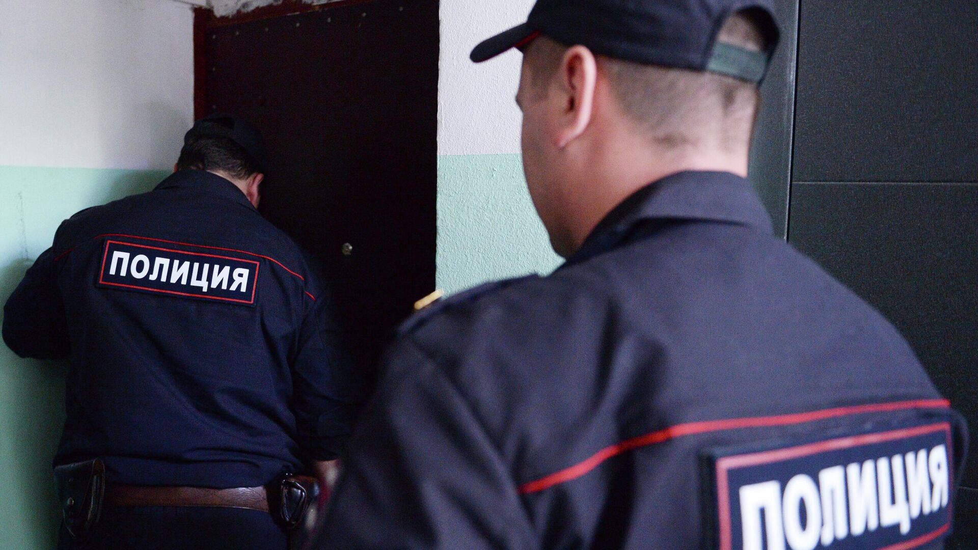 Сотрудники полиции стоят у двери квартиры - РИА Новости, 1920, 31.05.2022