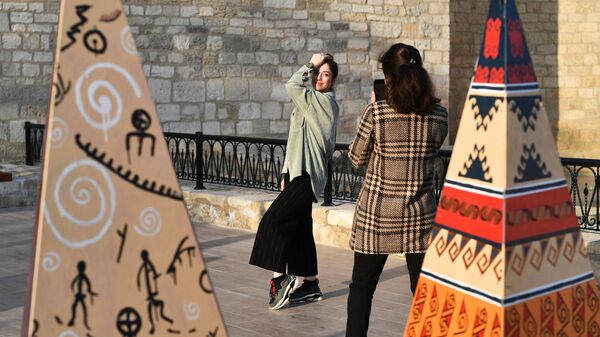 Девушки фотографируются на одной из улиц в Баку
