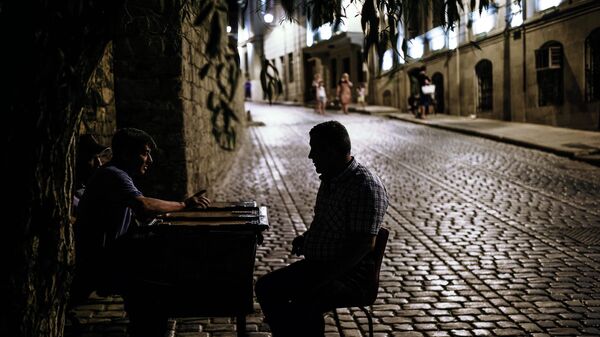 Мужчины играют в нарды на одной из улиц старого города в Баку 