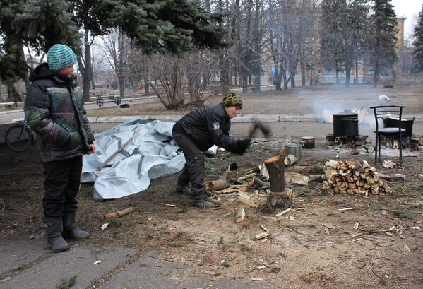 Дети колют дрова для костра, на котором готовят горячую пищу для жителей Дебальцево.