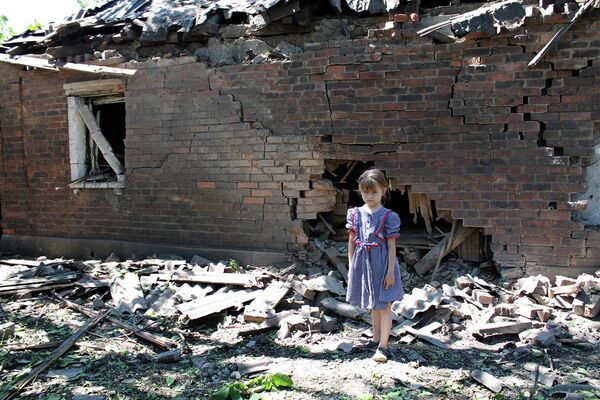 Девочка у дома, разрушенного в результате обстрела украинскими силовиками в Горловке. 