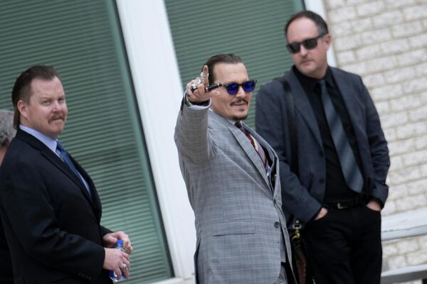 Актер Джонни Депп машет фанатам, покидая окружной суд округа Фэрфакс, штат Вирджиния. 26 мая 2022 года