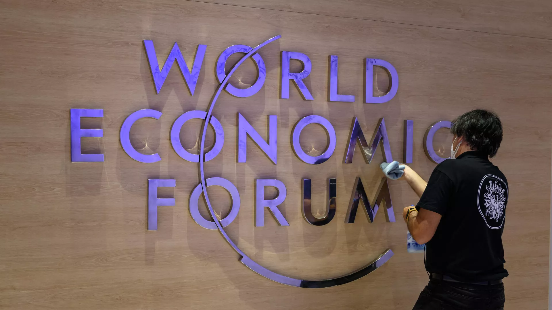 Рабочий чистит вывеску с логотипом Всемирного экономического форума в Давосе. 22 мая 2022 года - РИА Новости, 1920, 03.06.2022
