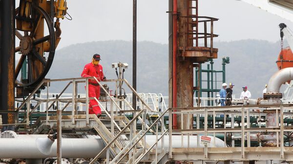 Венесуэльский нефтяник идет по нефтеперерабатывающему заводу Эль-Палито