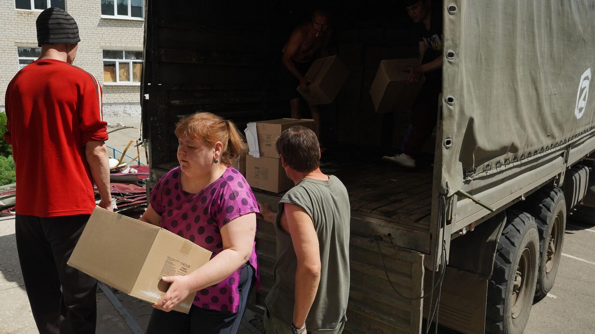 Местные жители разгружают коробки с гуманитарной помощью - РИА Новости, 1920, 21.05.2023