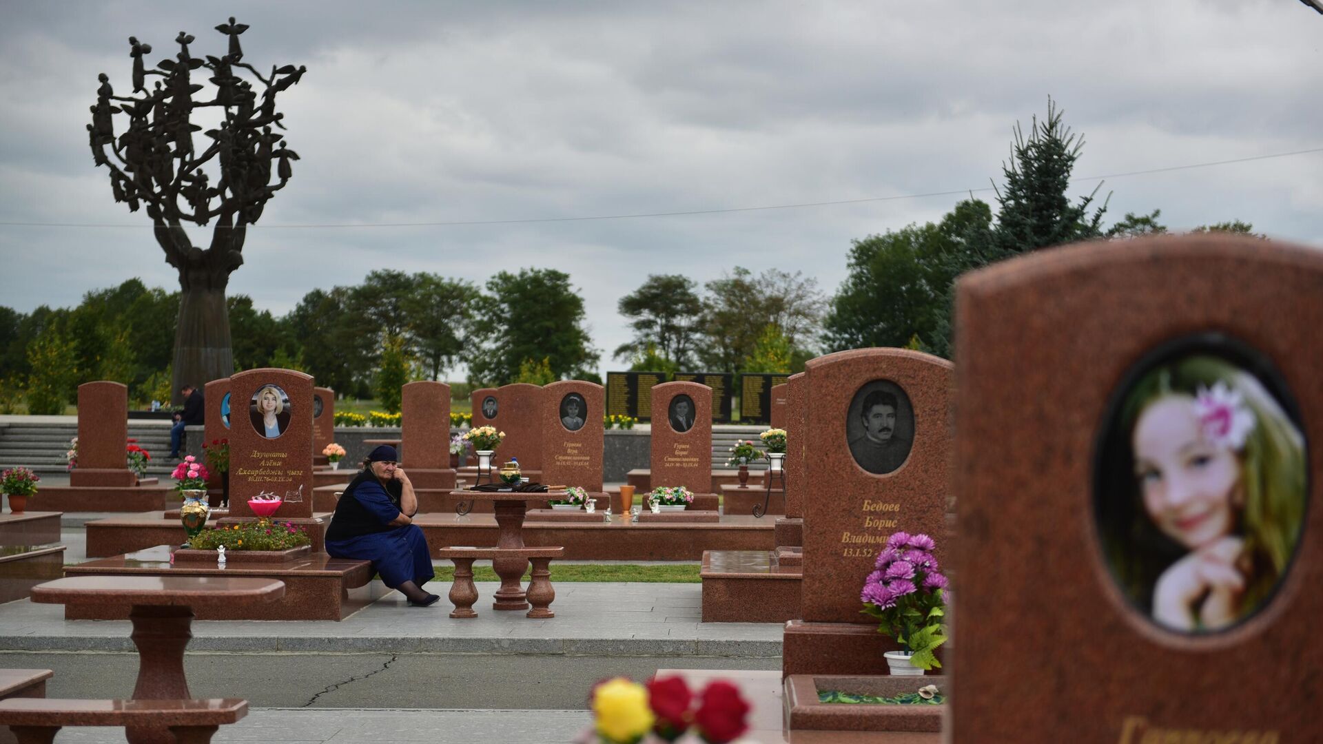 Женщина на мемориальном кладбище Город ангелов в Беслане, где похоронены погибшие во время террористического акта в сентябре 2004 года. - РИА Новости, 1920, 04.06.2022