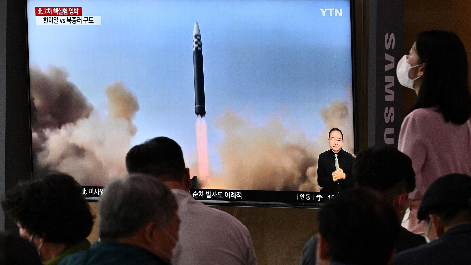 Люди возле экрана в Сеуле, транслирующего репортаж о запуске КНДР баллистической ракеты. 5 июня 2022 - РИА Новости, 1920, 05.06.2022