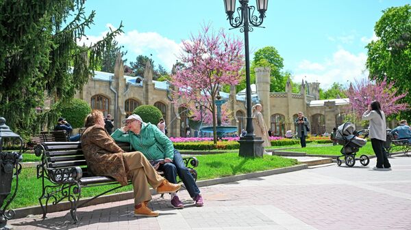 Туристы отдыхают на скамейке у Нарзанной галереи в Кисловодске