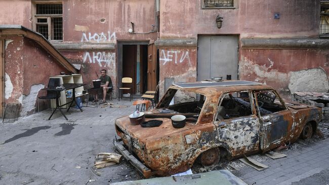 Поврежденный автомобиль на одной из улиц в Мариуполе