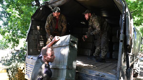 Бойцы Народной милиции ЛНР разгружают боеприпасы рядом с огневой позицией артиллерийского расчета на окраине Попасной