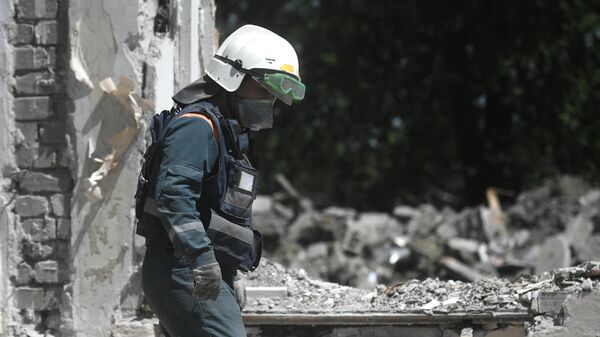 Сотрудник МЧС РФ разбирает завалы разрушенного здания в Мариуполе