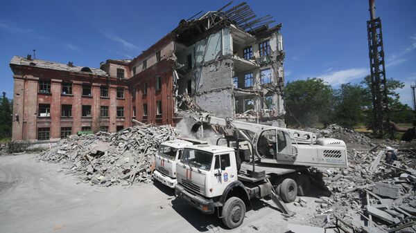 Сотрудники МЧС РФ разбирают завалы разрушенного здания школы в Мариуполе