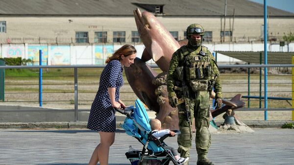 Женщина с ребенком и российский военный в Херсоне