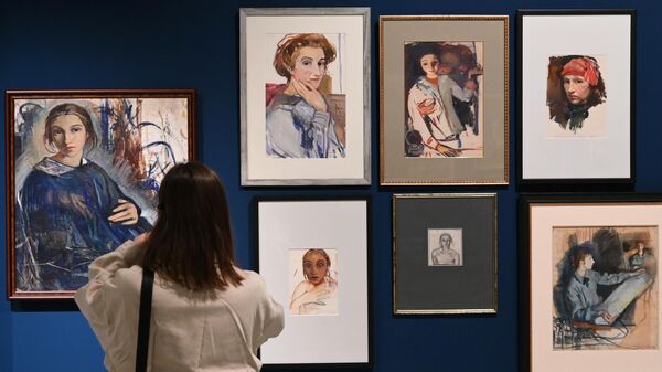 Посетительница фотографирует картины, представленные на выставке Точки зрения в Музее русского импрессионизма в Москве