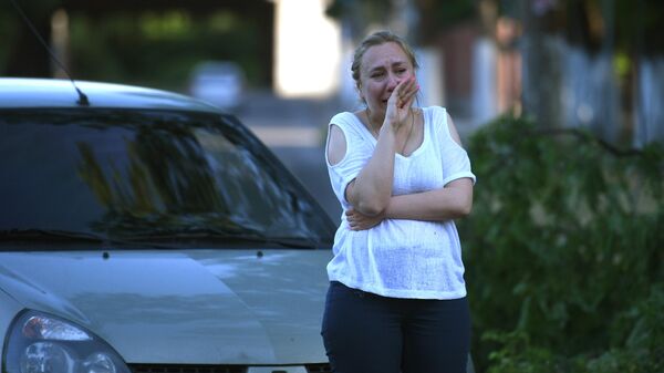 Женщина плачет возле машины в Донецке. 9 июня 2022