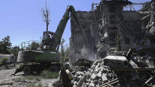 Сотрудники МЧС России разбирают завалы разрушенного дома на одной из улиц в Мариуполе