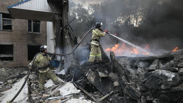 Сотрудники МЧС ДНР тушат пожар в Донецке после обстрелов со стороны ВСУ