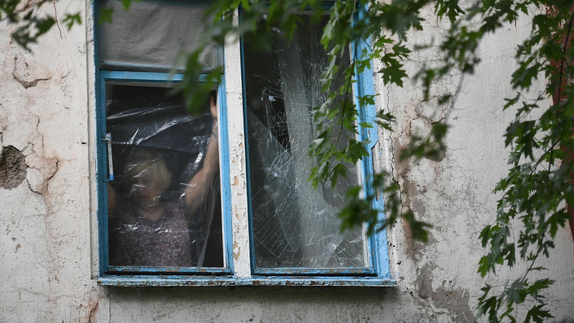 Μια γυναίκα καλύπτει ένα παράθυρο με πλαστική μεμβράνη - RIA Novosti, 1920, 06/04/2023