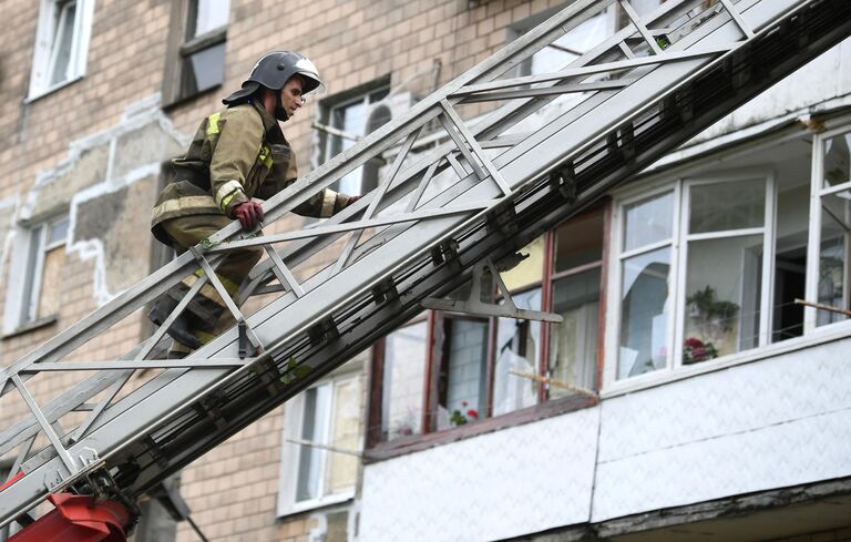 Сотрудник МЧС ДНР на стреле пожарной машины во время ликвидации последствий обстрелов со стороны ВСУ Донецка