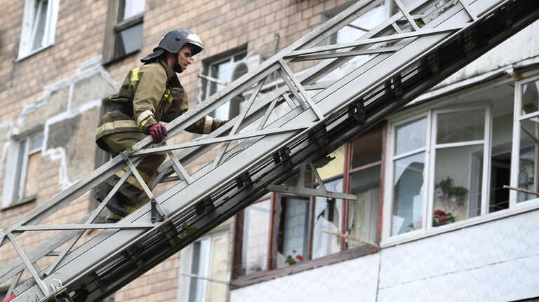 Сотрудник МЧС ДНР на стреле пожарной машины во время ликвидации последствий обстрелов со стороны ВСУ Донецка
