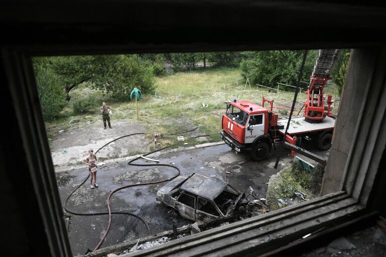 Машина МЧС ДНР возле дома, где возник пожар в результате обстрелов со стороны ВСУ Донецка