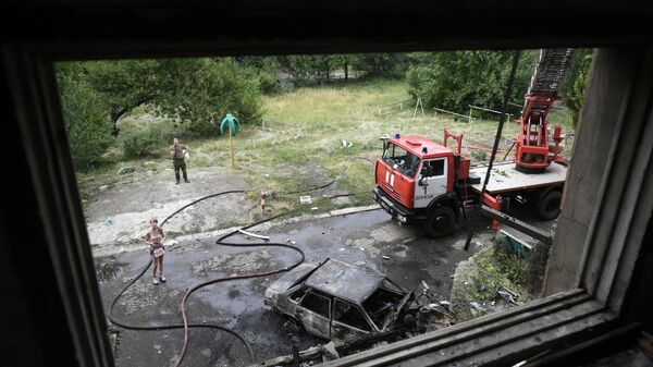 A vehicle belonging to the Ministry of Emergencies of the DPR near the house, which caught fire as a result of the shelling of the Donetsk Armed Forces