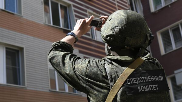 Сотрудник Следственного комитета фиксирует последствия попадания снаряда ВСУ в крышу роддома в Донецке