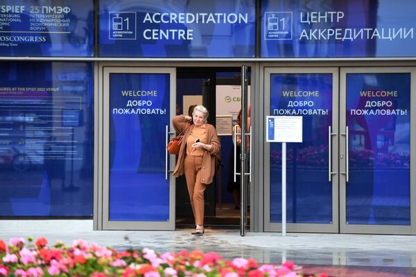Женщина выходит из центра аккредитации Петербургского международного экономического форума – 2022 в Санкт-Петербурге