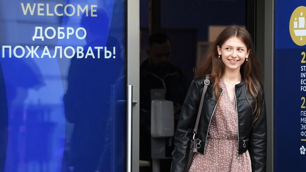 Девушка выходит из центра аккредитации Петербургского международного экономического форума – 2022 (ПМЭФ) в Санкт-Петербурге