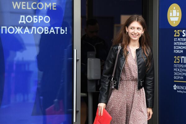 Девушка выходит из центра аккредитации Петербургского международного экономического форума – 2022 (ПМЭФ) в Санкт-Петербурге