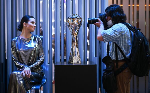 Фотограф снимает награду футбольного клуба Зенит - кубок Премьер-лиги РПЛ сезона 2021/2022 на выставке XXV Петербургского международного экономического форума