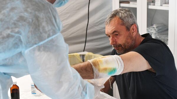 Военный врач ВС РФ обрабатывает рану военнослужащему ВСУ в лазарете 